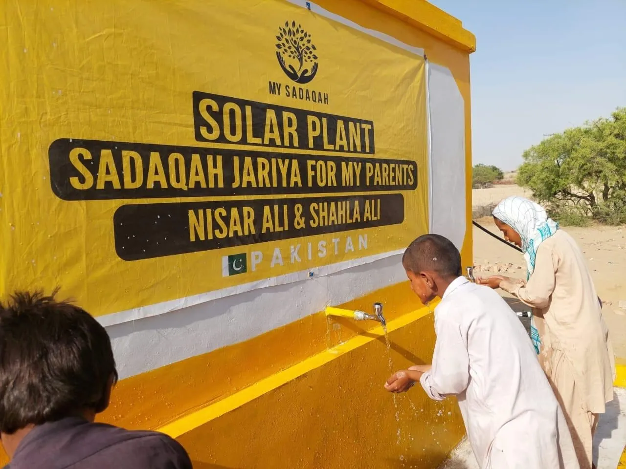 A man drinks from a tap at a My Sadaqah solar water plant given as Sadaqah Jariyah